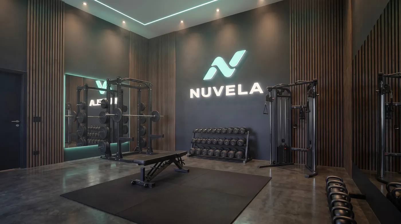 A gym with a power rack, a barbell, an adjustable bench, a dumbbell rack, a cable station and kettlebells